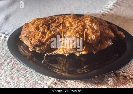 rouleaux de poulet farcis rôtis placés sur une assiette noire, espace de copie restant. Banque D'Images