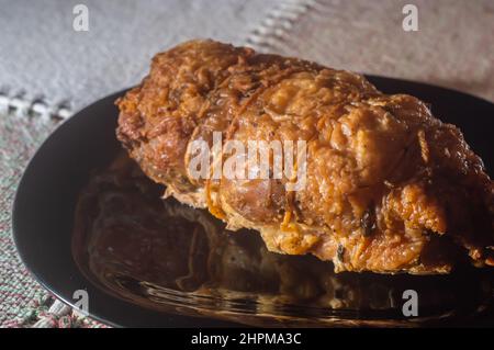 rouleaux de poulet farcis rôtis placés sur une assiette noire, espace de copie restant. Banque D'Images