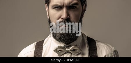 Portrait de beau barbu homme en chemise blanche et noeud papillon, bretelles. Gros plan d'un homme son noeud papillon. Homme de barbe en noeud papillon et bretelles. Homme Banque D'Images