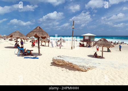 Les touristes se baignent au soleil sur la plage de Delphin de Cancun par une journée ensoleillée au bord de la mer des Caraïbes, péninsule du Yucatan, Mexique. Banque D'Images