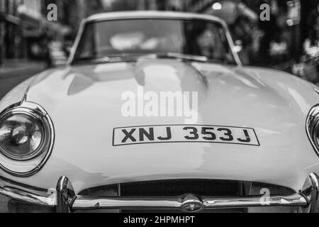 Une image en noir et blanc d'une voiture classique dans le centre de Londres. Banque D'Images