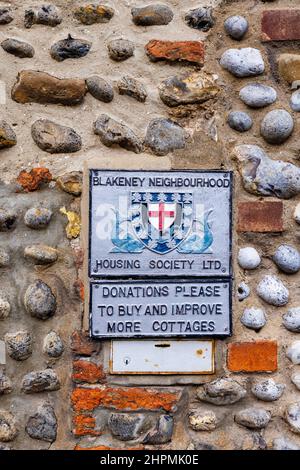 Plaque murale de Blakeney Neighborhood Housing Society Ltd sur une maison à Blakeney, un petit village côtier de la côte nord de Norfolk, en Angleterre Banque D'Images