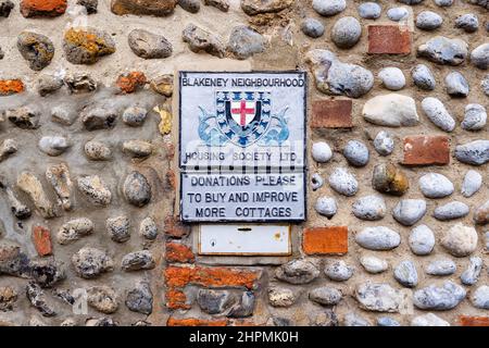 Plaque murale de Blakeney Neighborhood Housing Society Ltd sur une maison à Blakeney, un petit village côtier de la côte nord de Norfolk, en Angleterre Banque D'Images