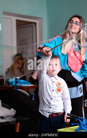 Dolyna, Ukraine 28 mai 2021: Animateurs et bulles de savon pour des vacances d'enfants, un garçon faisant une grosse bulle à lui seul, un spectacle amusant et divertissant. Banque D'Images