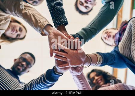 Theres puissance dans l'unité. Portrait d'un groupe de jeunes amis en bas angle. Banque D'Images