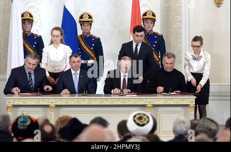 Le Président russe Vladimir Poutine signe l'accord sur l'adhésion de la République de Crimée à la Fédération de Russie en 2014. Banque D'Images