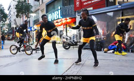 Izmir, Alsancak. Turquie, 21/02/2022, des danseurs de rue qui ont été émigrés en Turquie de la République du Ghana, en Afrique, exécutent leur art de rue dans le quartier le plus populaire d'Izmir, à Alsancak. Un groupe de danseuses africaines, composé de jeunes étudiants, exécute chaque jour leur art à la foule avec un rythme long et élevé. Leur gain financier vient des gens de la rue qui regardent et apprécient leur art. Banque D'Images