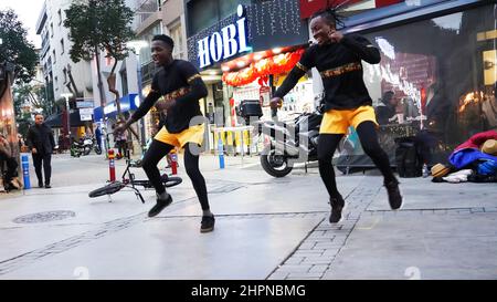 Izmir, Alsancak. Turquie, 21/02/2022, des danseurs de rue qui ont été émigrés en Turquie de la République du Ghana, en Afrique, exécutent leur art de rue dans le quartier le plus populaire d'Izmir, à Alsancak. Un groupe de danseuses africaines, composé de jeunes étudiants, exécute chaque jour leur art à la foule avec un rythme long et élevé. Leur gain financier vient des gens de la rue qui regardent et apprécient leur art. Banque D'Images