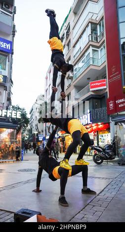 Izmir, Alsancak. Turquie, 21/02/2022, des danseurs de rue qui ont été émigrés en Turquie de la République du Ghana, en Afrique, exécutent leur art de rue dans le quartier le plus populaire d'Izmir, à Alsancak. Un groupe de danseuses africaines, composé de jeunes étudiants, exécute chaque jour leur art à la foule avec un rythme long et élevé. Leur gain financier vient des gens de la rue qui regardent et apprécient leur art. Banque D'Images