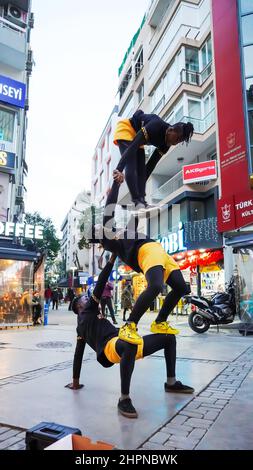 Izmir, Alsancak. Turquie, 21/02/2022, des danseurs de rue qui ont été émigrés en Turquie de la République du Ghana, en Afrique, exécutent leur art de rue dans le quartier le plus populaire d'Izmir, à Alsancak. Un groupe de danseuses africaines, composé de jeunes étudiants, exécute chaque jour leur art à la foule avec un rythme long et élevé. Leur gain financier vient des gens de la rue qui regardent et apprécient leur art. Banque D'Images