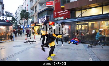 Izmir, Alsancak. Turquie, 21/02/2022, des danseurs de rue qui ont été émigrés en Turquie de la République du Ghana, en Afrique, exécutent leur art de rue dans le quartier le plus populaire d'Izmir, à Alsancak. Un groupe de danseuses africaines, composé de jeunes étudiants, exécute chaque jour leur art à la foule avec un rythme long et élevé. Leur gain financier vient des gens de la rue qui regardent et apprécient leur art. Banque D'Images