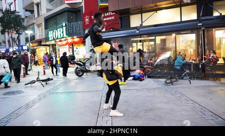 Izmir, Alsancak. Turquie, 21/02/2022, des danseurs de rue qui ont été émigrés en Turquie de la République du Ghana, en Afrique, exécutent leur art de rue dans le quartier le plus populaire d'Izmir, à Alsancak. Un groupe de danseuses africaines, composé de jeunes étudiants, exécute chaque jour leur art à la foule avec un rythme long et élevé. Leur gain financier vient des gens de la rue qui regardent et apprécient leur art. Banque D'Images