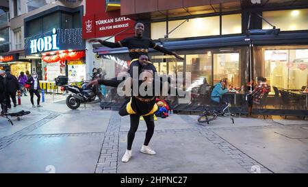 Izmir, Alsancak. Turquie, 21/02/2022, des danseurs de rue qui ont été émigrés en Turquie de la République du Ghana, en Afrique, exécutent leur art de rue dans le quartier le plus populaire d'Izmir, à Alsancak. Un groupe de danseuses africaines, composé de jeunes étudiants, exécute chaque jour leur art à la foule avec un rythme long et élevé. Leur gain financier vient des gens de la rue qui regardent et apprécient leur art. Banque D'Images