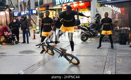 Izmir, Alsancak. Turquie, 21/02/2022, des danseurs de rue qui ont été émigrés en Turquie de la République du Ghana, en Afrique, exécutent leur art de rue dans le quartier le plus populaire d'Izmir, à Alsancak. Un groupe de danseuses africaines, composé de jeunes étudiants, exécute chaque jour leur art à la foule avec un rythme long et élevé. Leur gain financier vient des gens de la rue qui regardent et apprécient leur art. Banque D'Images