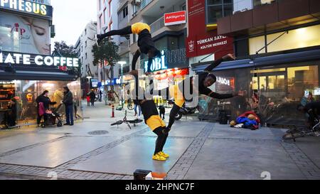 Izmir, Alsancak. Turquie, 21/02/2022, des danseurs de rue qui ont été émigrés en Turquie de la République du Ghana, en Afrique, exécutent leur art de rue dans le quartier le plus populaire d'Izmir, à Alsancak. Un groupe de danseuses africaines, composé de jeunes étudiants, exécute chaque jour leur art à la foule avec un rythme long et élevé. Leur gain financier vient des gens de la rue qui regardent et apprécient leur art. Banque D'Images