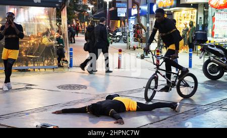 Izmir, Alsancak. Turquie, 21/02/2022, des danseurs de rue qui ont été émigrés en Turquie de la République du Ghana, en Afrique, exécutent leur art de rue dans le quartier le plus populaire d'Izmir, à Alsancak. Un groupe de danseuses africaines, composé de jeunes étudiants, exécute chaque jour leur art à la foule avec un rythme long et élevé. Leur gain financier vient des gens de la rue qui regardent et apprécient leur art. Banque D'Images