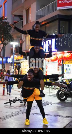 Izmir, Alsancak. Turquie, 21/02/2022, des danseurs de rue qui ont été émigrés en Turquie de la République du Ghana, en Afrique, exécutent leur art de rue dans le quartier le plus populaire d'Izmir, à Alsancak. Un groupe de danseuses africaines, composé de jeunes étudiants, exécute chaque jour leur art à la foule avec un rythme long et élevé. Leur gain financier vient des gens de la rue qui regardent et apprécient leur art. Banque D'Images