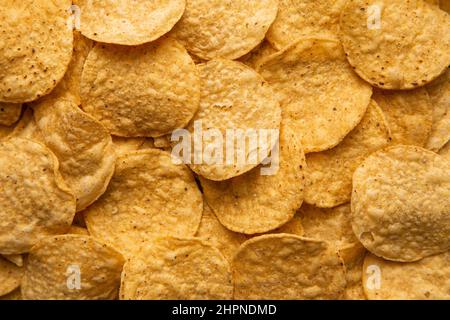 Une image de gros plan de chips de tortilla de maïs jaune fraîchement cuites et salées. Banque D'Images