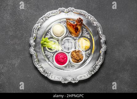 Assiette de Pâque Seder avec nourriture traditionnelle sur fond sombre Banque D'Images