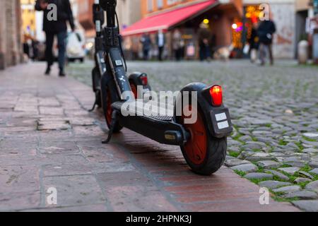 Deux trottinettes électriques partagées garées sur un sentier dans le centre-ville, Modène, Italie Banque D'Images