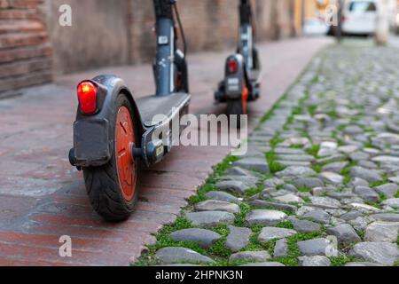 Deux trottinettes électriques partagées garées sur un sentier dans le centre-ville, Modène, Italie Banque D'Images