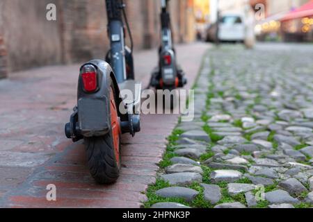 Deux trottinettes électriques partagées garées sur un sentier dans le centre-ville, Modène, Italie Banque D'Images