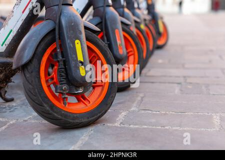 Une rangée de trottinettes électriques à roues partagées dans une place publique de la ville de Modène, Italie Banque D'Images