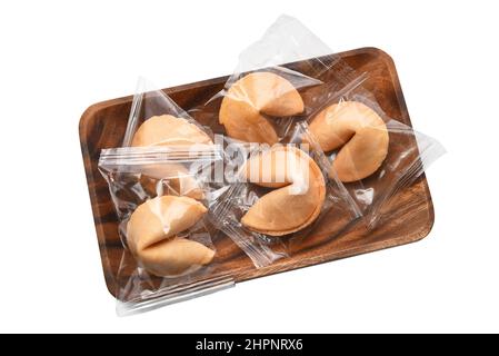 Une assiette pleine de biscuits fortune encore enveloppée dans le plastique, isolée sur blanc. Banque D'Images