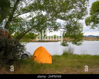 Le camping libre avec une tente au bord d'un lac en Nouvelle-Zélande, en été, est une activité populaire pour les voyageurs et les pêcheurs Banque D'Images