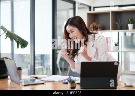 Femme asiatique Blogger porter le costume blanc excitant et de parler avec les suiveurs, streaming en direct sur l'application de médias sociaux. Concept de travail indépendant à domicile. Banque D'Images