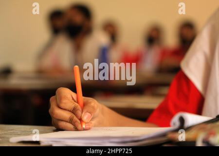 Dhaka, Bangladesh. 22nd févr. 2022. Un étudiant prend des notes en classe alors que les écoles rouvrent à Dhaka. Le Bangladesh rouvre des établissements d'enseignement à mesure que les cas de coronavirus commencent à diminuer. Crédit : SOPA Images Limited/Alamy Live News Banque D'Images