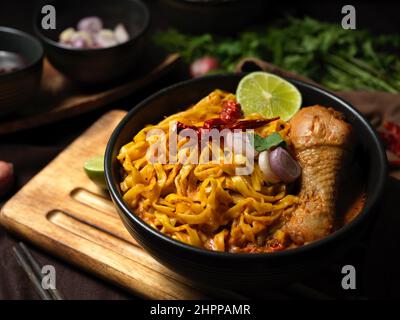 Célèbre cuisine du nord de la Thaïlande, Khao soi Kai, nouilles aux œufs dans une soupe de curry jaune avec poulet. Banque D'Images