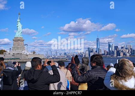 Les passagers du ferry pour Liberty Island bénéficient d'une vue imprenable sur la Statue et les gratte-ciel de New York Banque D'Images