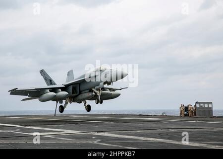 MER DES PHILIPPINES (fév 22, 2022) un F/A-18E Super Hornet, affecté aux « Tophatters » du Strike Fighter Squadron (VFA) 14, se prépare à faire un atterrissage arrêté sur le pont de vol du porte-avions de la classe Nimitz USS Abraham Lincoln (CVN 72). Abraham Lincoln Strike Group est en cours de déploiement prévu dans la zone d'exploitation de la flotte américaine 7th afin d'améliorer l'interopérabilité par le biais d'alliances et de partenariats tout en servant de force d'intervention prête à l'emploi pour soutenir une région Indo-Pacifique libre et ouverte. (É.-U. Photo de la marine par Michael Singley, spécialiste des communications de masse, classe 3rd) Banque D'Images