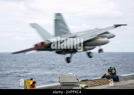 MER DES PHILIPPINES (fév 22, 2022) Aviation Boatswain's Mate (Equipment) 2nd classe Darlan le rapaing, de Waipahu, Hawaii, observe les opérations de vol sur le pont de vol du porte-avions USS Abraham Lincoln de la classe Nimitz (CVN 72). Abraham Lincoln Strike Group est en cours de déploiement prévu dans la zone d'exploitation de la flotte américaine 7th afin d'améliorer l'interopérabilité par le biais d'alliances et de partenariats tout en servant de force d'intervention prête à l'emploi pour soutenir une région Indo-Pacifique libre et ouverte. (É.-U. Photo de la marine par Michael Singley, spécialiste des communications de masse, classe 3rd) Banque D'Images