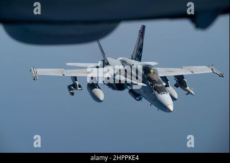 Un corps maritime américain F/A-18 Hornet reçoit du carburant d'un prolongateur KC-10A de la US Air Force, affecté à l'escadron de ravitaillement aérien expéditionnaire 908th à la base aérienne Al Dhafra, Émirats arabes Unis, lors d'un exercice d'opérations aériennes de la marine américaine dans la guerre maritime de surface dans le golfe d'Oman, le 16 février 2022. L'exercice AOMSW valide les capacités de la force conjointe en pratiquant l'intégration des forces aériennes et navales dans la zone de responsabilité du Commandement central des États-Unis. (É.-U. Photo de la Force aérienne par le premier Airman Daniel Hernandez) Banque D'Images