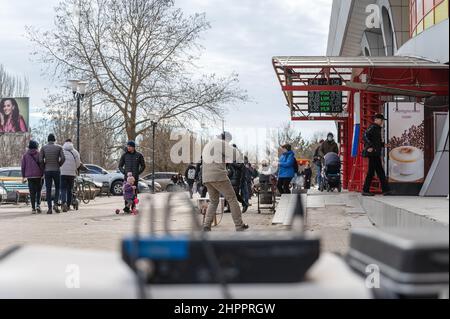 Un musicien de rue recueille des documents en face d'un centre commercial. Un homme mature avec un violon électronique. Les passants écoutent la pièce du musicien. Vue de behin Banque D'Images