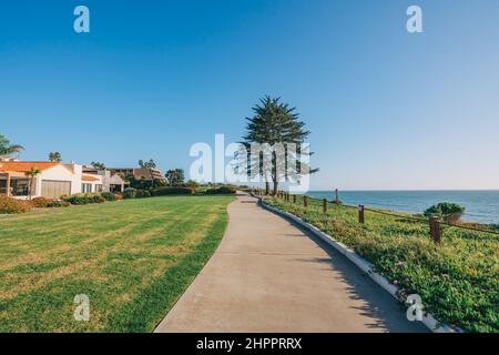 Longue promenade le long de la rive, maisons avec beau paysage devant la cour et ciel bleu clair sur fond dans une petite ville de plage en Californie. Banque D'Images