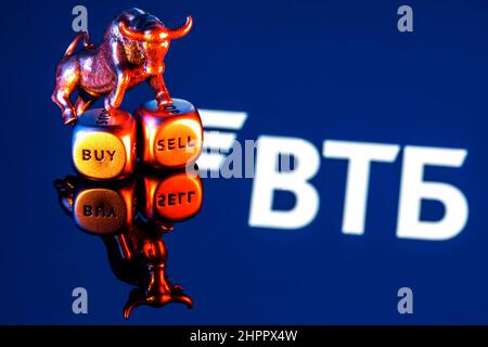 Le taureau en métal se dresse sur des dés d'achat-vente sur le fond du logo de la banque VTB Banque D'Images