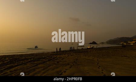 Un groupe de pêcheurs jette leurs filets dans la mer tôt le matin sur la côte de Fujairah dans les Émirats arabes Unis. Banque D'Images
