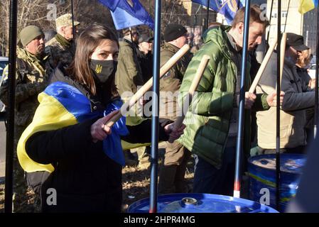 Non exclusif: KIEV, UKRAINE - 22 FÉVRIER 2022 - Une fille avec un drapeau ukrainien sur ses épaules bat un canon à brûler pendant que l'Empire a dû mourir de rall Banque D'Images