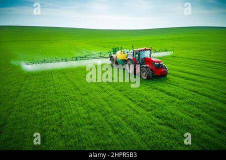 Vue aérienne de l'agriculture tracteur labourer et pulvériser sur terrain. Banque D'Images