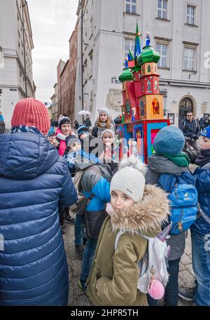 Les écoliers portant la scène de la nativité de Cracovie Szopka, faite par eux à l'école, pour exposition lors du concours annuel de décembre, événement inclus dans la liste du patrimoine culturel de l'UNESCO, à la place du marché principal, Cracovie, Pologne Banque D'Images