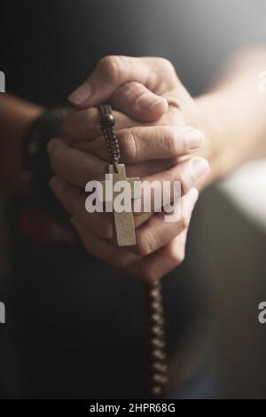 Fidèle à sa religion. Mains jointes et tenue d'un Rosaire dans la prière. Banque D'Images