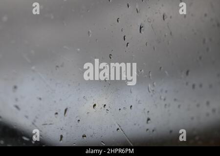 Macro gouttes d'eau sur une fenêtre. Pluie en voyage. Jour de pluie. Nuages lourds. Ciel nuageux. Arrière-plan gris. Galway. Irlande. Banque D'Images