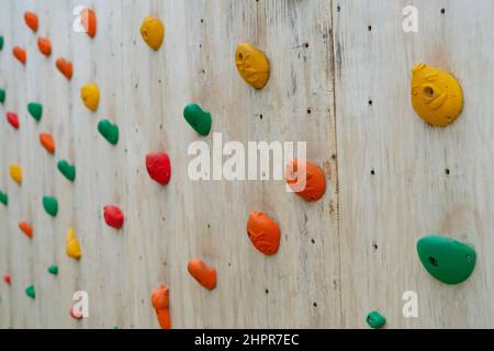 l'escalade colorée se tient sur un mur d'escalade en bois Banque D'Images