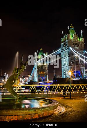 Image nocturne d'une statue d'un garçon et d'un dauphin jouant avec un Tower Bridge illuminé en arrière-plan. Novembre 2017 Banque D'Images