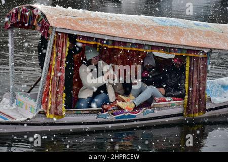 Cachemire, Inde. 23rd févr. 2022. Les touristes indiens prennent des photos sur le bateau shikara lors de fortes chutes de neige à Srinagar.la plupart des régions de la vallée du Cachemire ont reçu mercredi des chutes de neige - la première chute lourde de la saison dans les plaines - perturbant les opérations de vol et de chemin de fer et conduisant à la fermeture de l'autoroute nationale vitale Srinagar-Jammu, les responsables ont dit ici. Crédit : SOPA Images Limited/Alamy Live News Banque D'Images