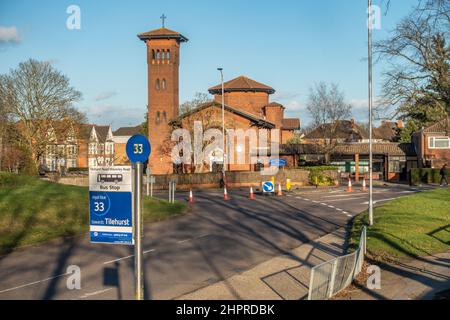 33 Arrêt de bus devant l'église catholique des Martyrs anglais à Tilehurst, Reading, Royaume-Uni. Les cônes et les panneaux routiers en arrière-plan détournent la circulation. Banque D'Images