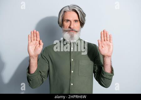 Portrait d'un homme gris calme et attrayant montrant un signe d'arrêt sans rejet isolé sur fond gris pastel Banque D'Images